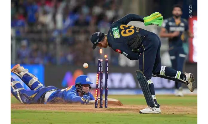 GT wicket keeper attempting run out during match against Mumbai Indians. GT wicket keeper attempting run out during match against Mumbai Indians.