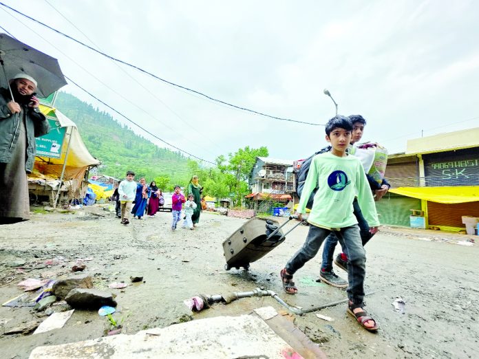 A family shifts to safer area from Uri on Friday. -Excelsior/Aabid Nabi