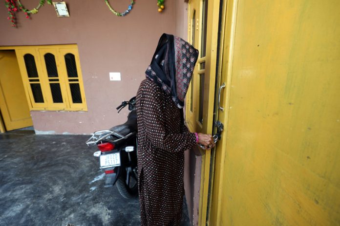 A woman locks her house to shift to a safer place from the border in Jammu on Wednesday. -Excelsior/Rakesh