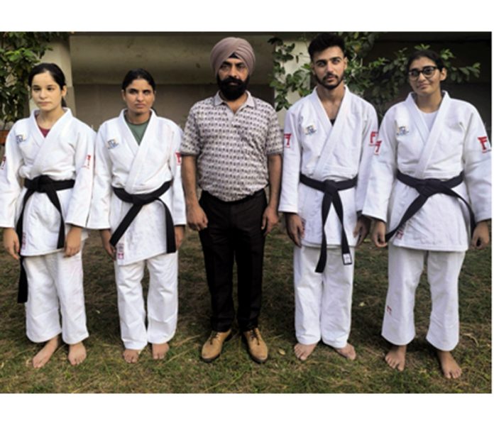 Judo players posing along with coach Suraj Bhan Singh.