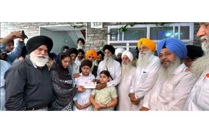 SGPC chief Advocate Harjinder Singh Dhami presenting a cheque of Rs 5 lakh to a family of deceased in Poonch.