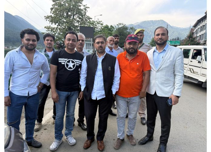 Minister Satish Sharma posing with tourists at Pahalgam on Tuesday.