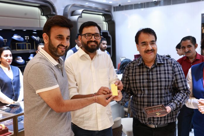 Vishal Tickoo receives 250 gm gold from executives of Talla Jewellers' Janipur showroom.