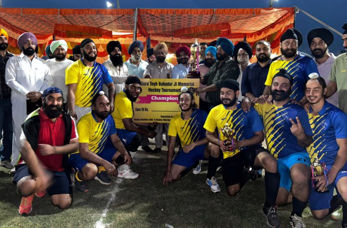 Winning team posing along with trophy.