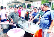 Volunteers offering sweet water to people at a stall in Jammu city on the occasion of Nirjala Ekadashi on Friday. -Excelsior/Rakesh