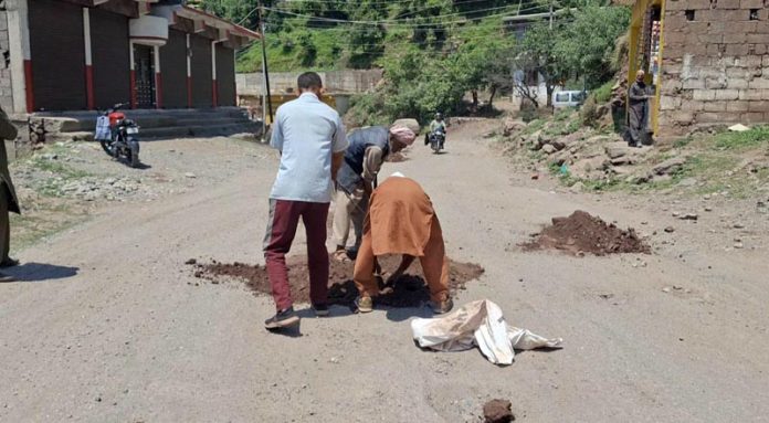 R&B authorities filling potholes with soil on Mandi road. -Excelsior/Waseem