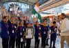 Students holding Tricolor and a photo of PM Narendra Modi during Vande Bharat's flag-off ceremony in Srinagar on Friday.