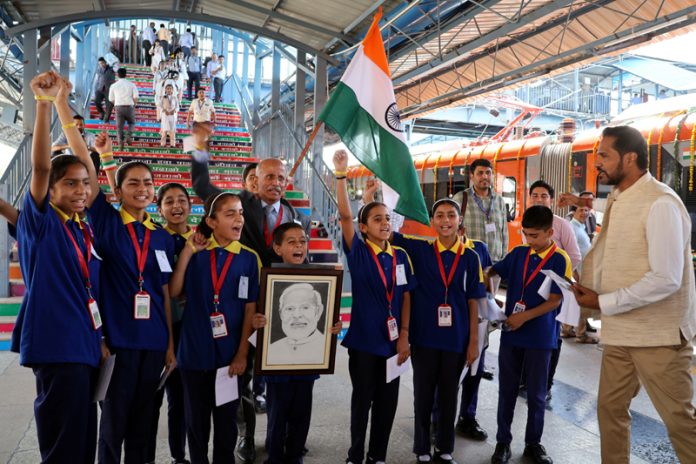 Students holding Tricolor and a photo of PM Narendra Modi during Vande Bharat's flag-off ceremony in Srinagar on Friday.