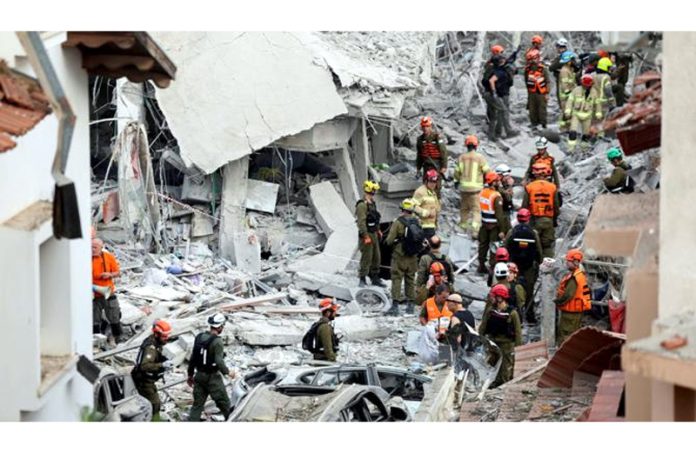 Rescue personnel at an impact site in Rishon LeZion following an Iranian missile attack on Israel.