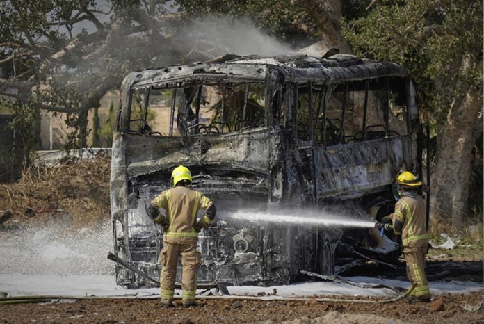 Firefighters work at site hit by missile launched from Iran in Central Israel on Tuesday.