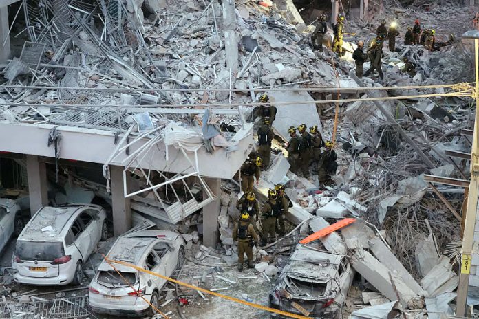 Responders work amid building rubble following a strike by an Iranian missile in the Israeli city of Bat Yam on Sunday.