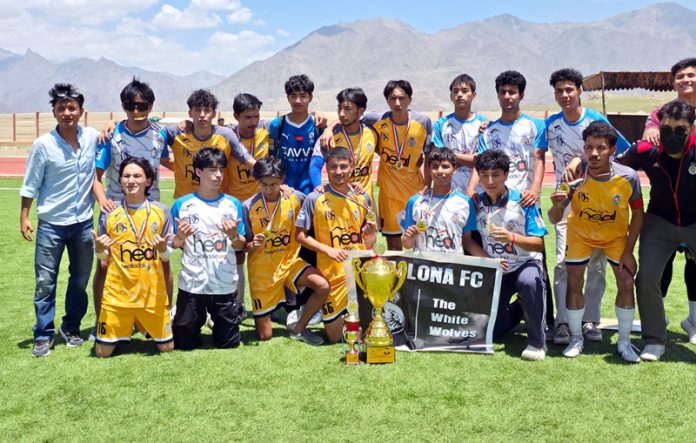 Winning team posing along with trophy and medals.
