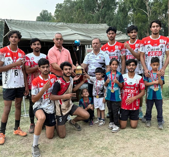 Winning team posing along with trophy.