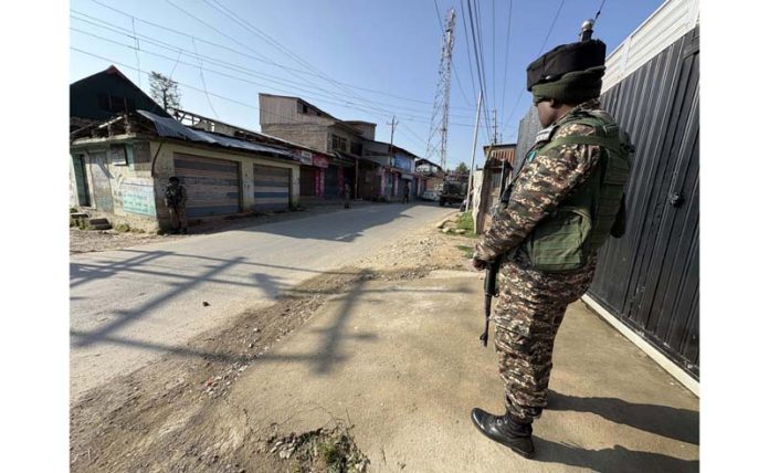 A security personnel stands guard during NIA raids in Kashmir on Thursday. -Excelsior/Sajad Dar A security personnel stands guard during NIA raids in Kashmir on Thursday. -Excelsior/Sajad Dar