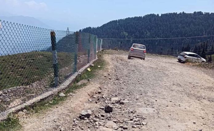 Vehicles navigating uneven and damaged road en route popular hill station Sanasar. Vehicles navigating uneven and damaged road en route popular hill station Sanasar.