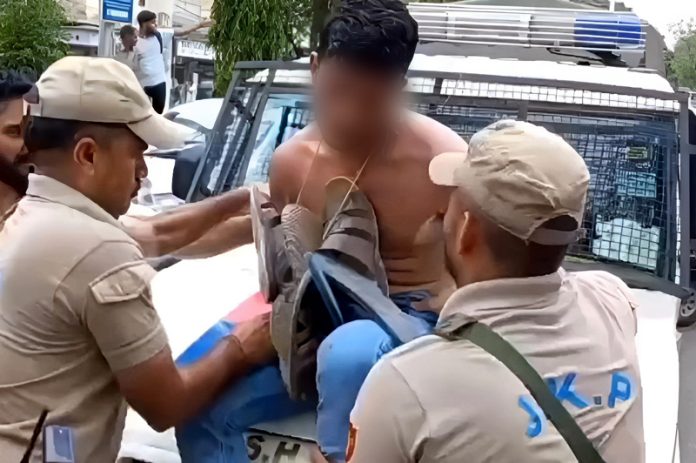 Cops making a robbery accused to sit on bonnet of a police official vehicle after parading him through Maheshpura Chowk, Jammu.