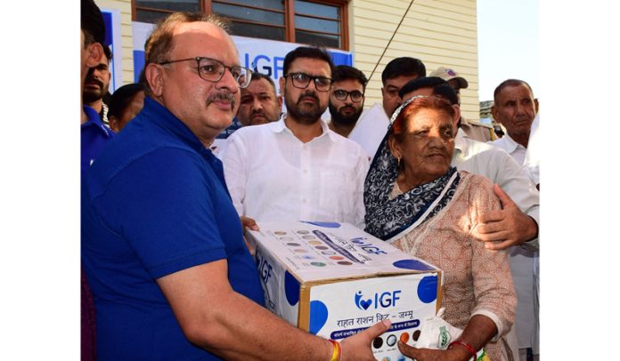 Minister Satish Sharma distributing relief kit to a resident affected by border firing. Minister Satish Sharma distributing relief kit to a resident affected by border firing.