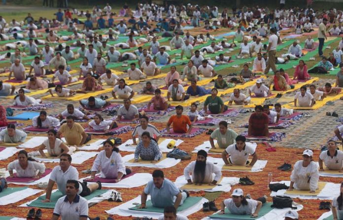 Hundreds of Yoga enthusiasts performing yoga asanas at Gulshan Ground Jammu. -Excelsior/Rakesh