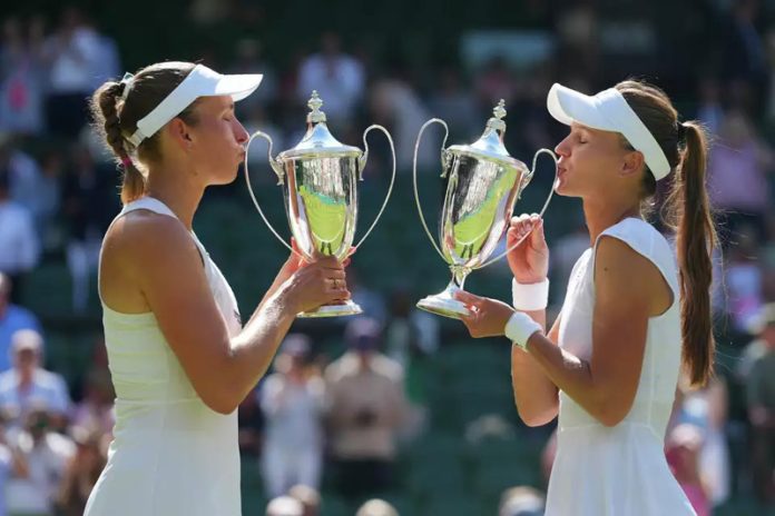 Veronika Kudermetova and Elise Mertens with their Wimbledon trophies after winning the women’s doubles final.
