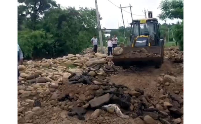 A JCB engaged in restoration work on the Maha Patti link road in Kathua district, which was washed away in a flash flood on Thursday. -Excelsior/Pardeep