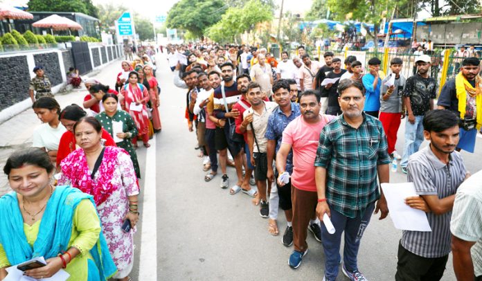 Shri Amarnath bound yatris waiting in long queues in front of Saraswati Dham near Railway Station on Saturday. —Excelsior/Rakesh