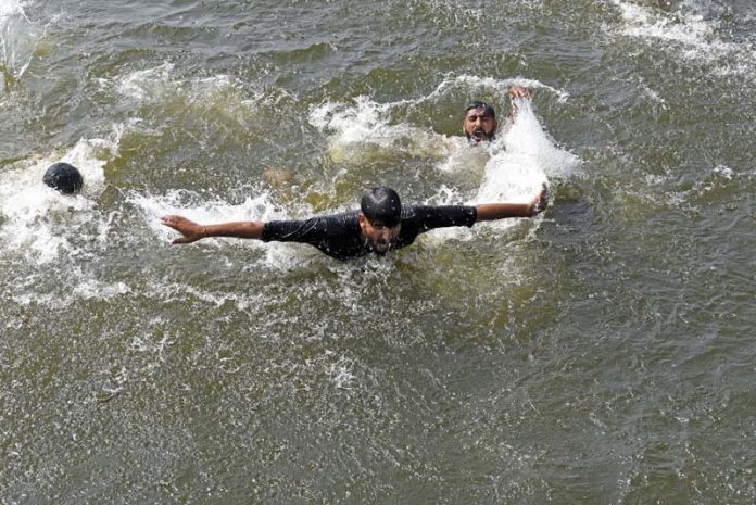Boys swim to beat the heat in waters of Dal lake in Srinagar on Saturday. -Excelsior/Shakeel Boys swim to beat the heat in waters of Dal lake in Srinagar on Saturday. -Excelsior/Shakeel