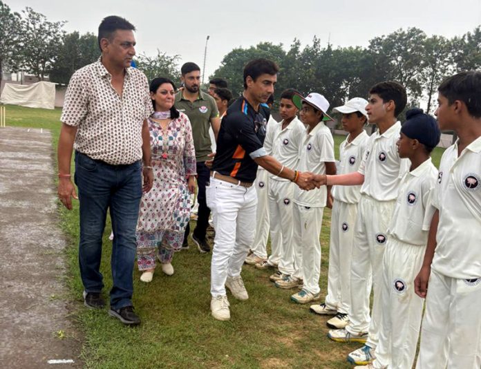 Mithun Manhas interacting with young players before the match.
