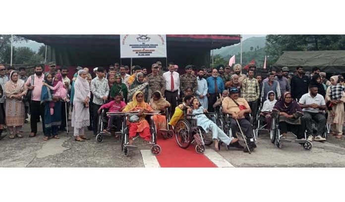 Army & NGO providing wheel chairs of specially-abled persons in Rajouri. -Excelsior/Imran