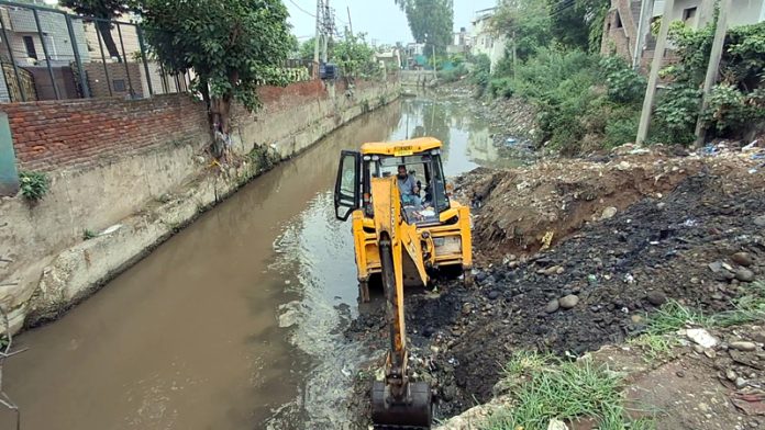 A JCB desilting a nallah at Nanak Nagar, Jammu on Friday. A JCB desilting a nallah at Nanak Nagar, Jammu on Friday.