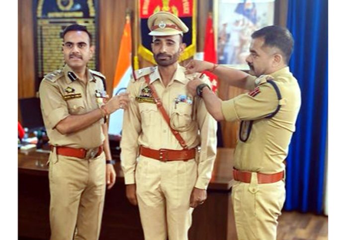 SSP Kishtwar, Naresh Singh pinning newly promoted ASI with new rank on Tuesday. -Excelsior/Tilak Raj