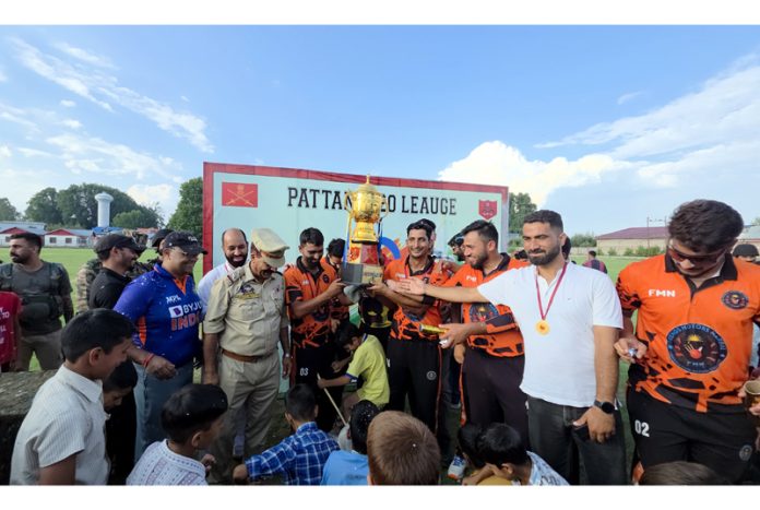 Winning team posing along with trophy.