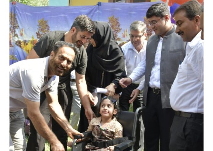 Child with special needs being given assistive aids during a camp at Ganderbal.