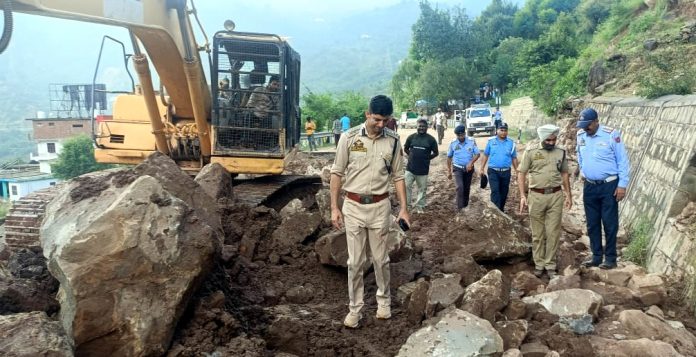 Police officials assessing restoration work of Jammu-Srinagar NH near Jakhaini in Udhampur district.