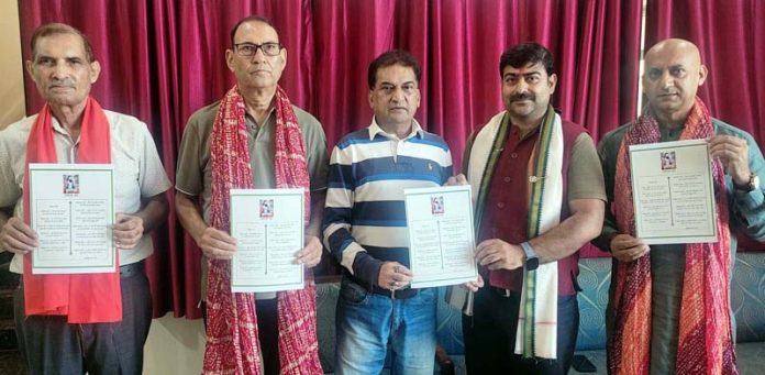 Dr Pardeep Mahotra releasing poem written by Balbir Ram Rattan in Jammu.