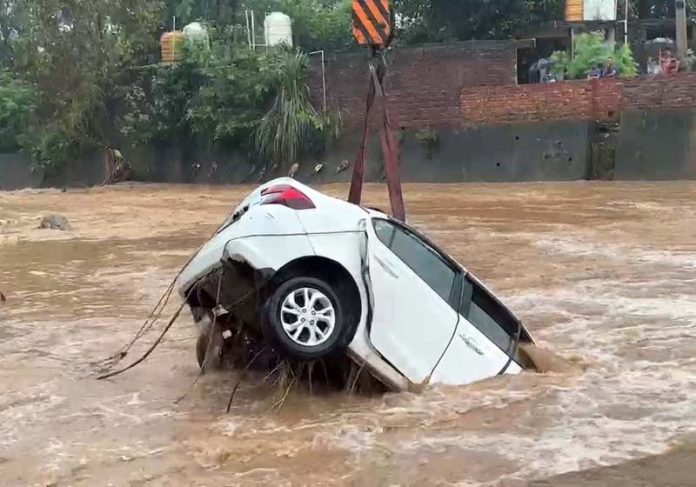 A car caught in flooded Nallah in Kathua on Saturday. -Excelsior/Pardeep