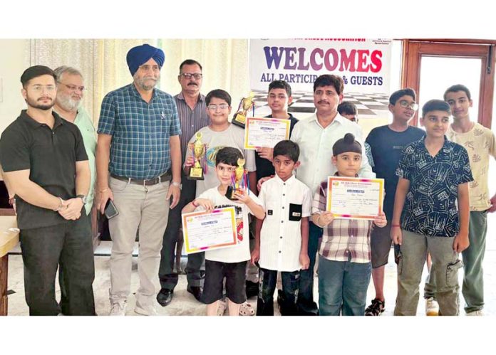 First four toppers of Under-13 Boys Chess Championship posing with officials.