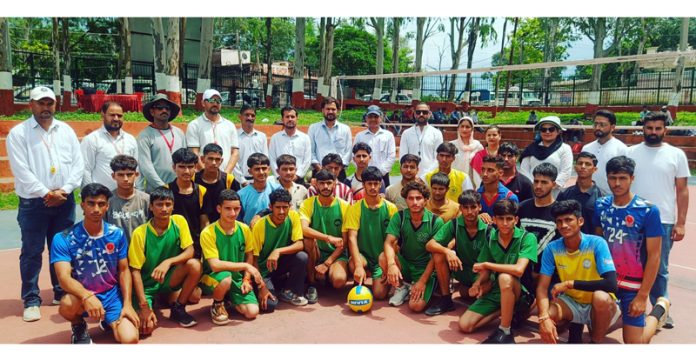 Volleyball players posing along with dignitaries.