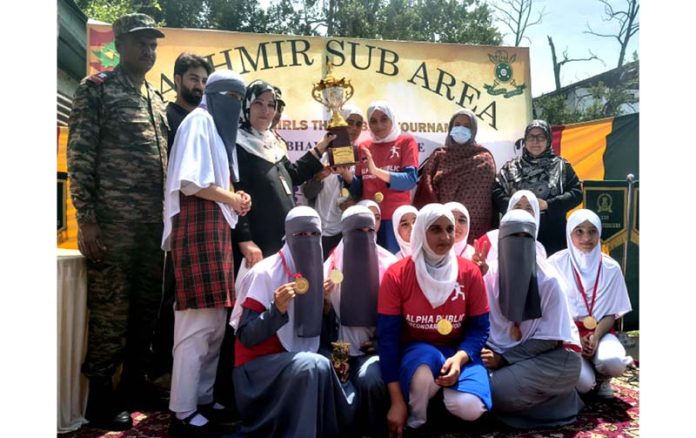 Winning team posing along trophy.