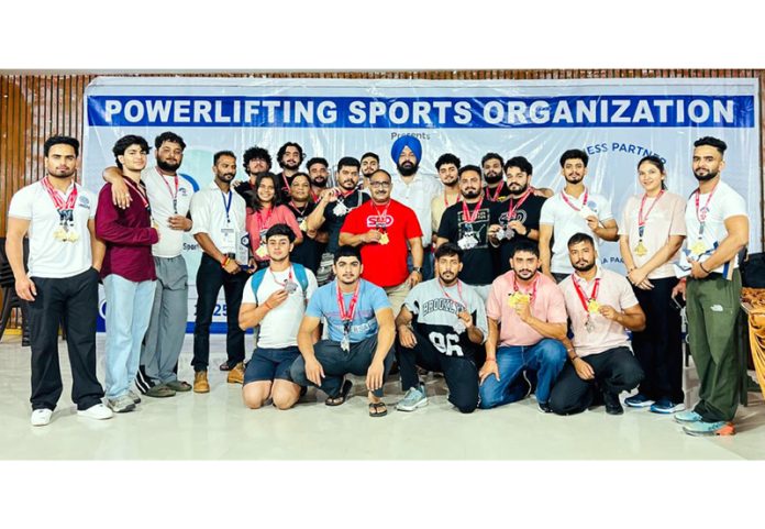 Powerlifters posing along with medals.