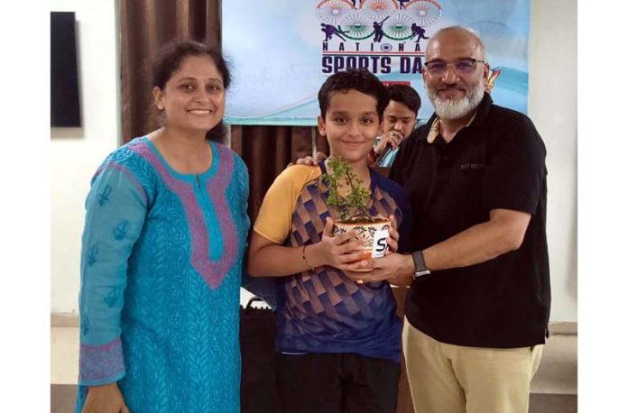 Participant receiving plant from dignitaries during a programme.