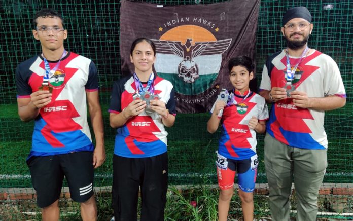 IHSA skaters posing with their coach after winning medals at National Roller Skating Championship.