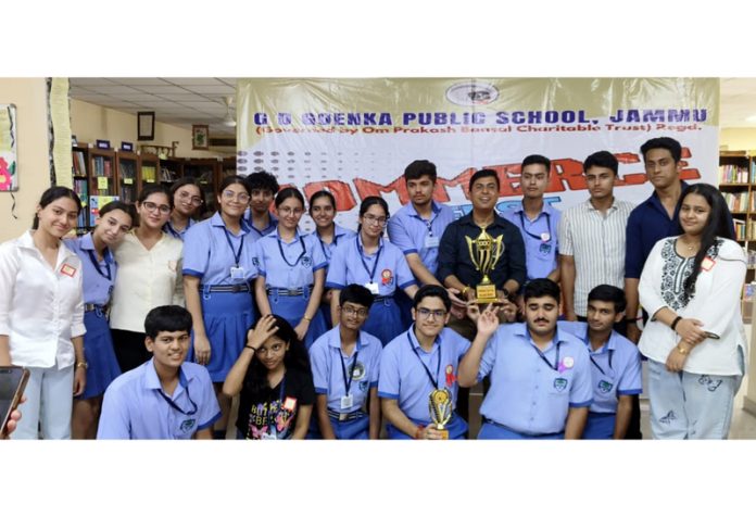 Winning team posing along with trophy.