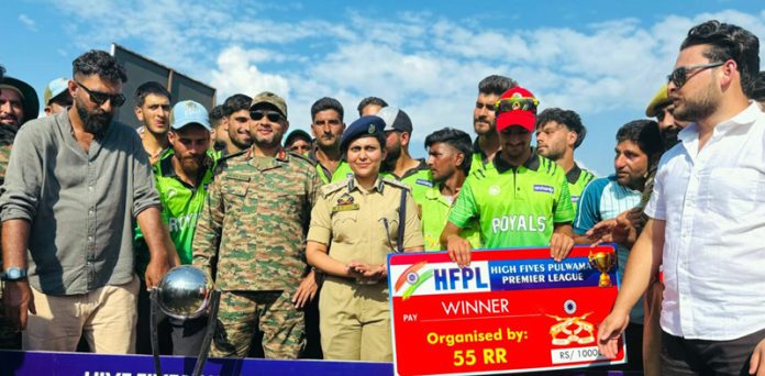 Winning team posing along with a trophy.