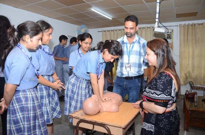 A student performing CPR during BLS workshop under guidance of Dr. Vanilla Chopra and Dr. Shruti Gupta.