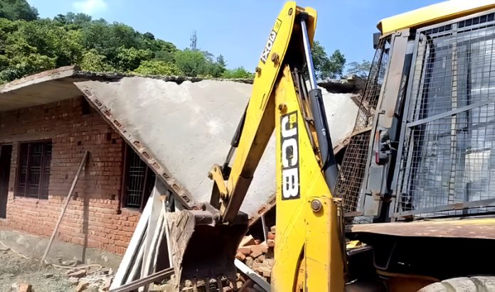 A JCB demolishing an illegal structure at Sidhra on Thursday.
