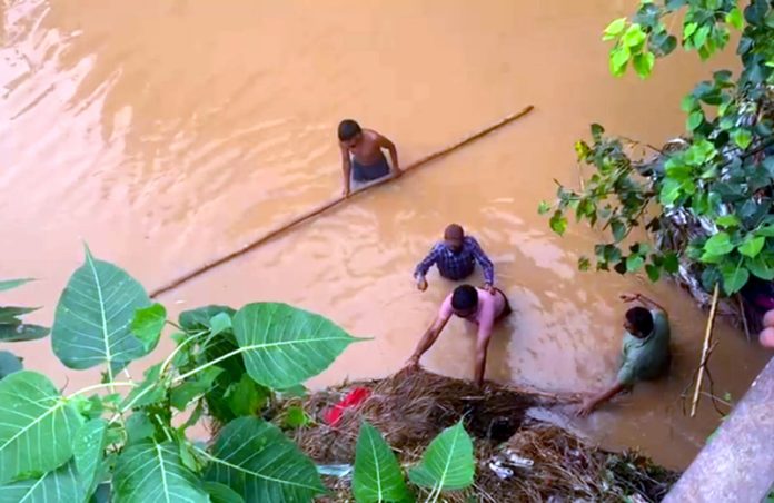 Locals clearing muck from a canal distributary in Akalpur area on Sunday.