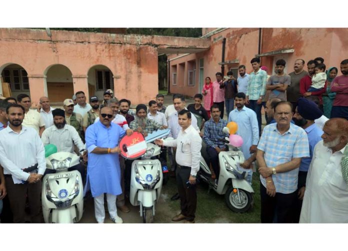 DyCM Surinder Choudhary distributing scooties among beneficiaries on Sunday.