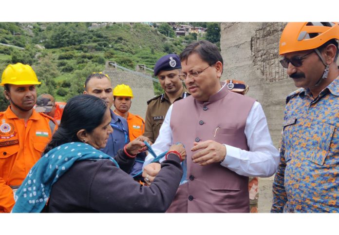 Chief Minister Pushkar Singh Dhami accepting the symbolic Rakhi from a disaster hit victim in Uttarkashi.