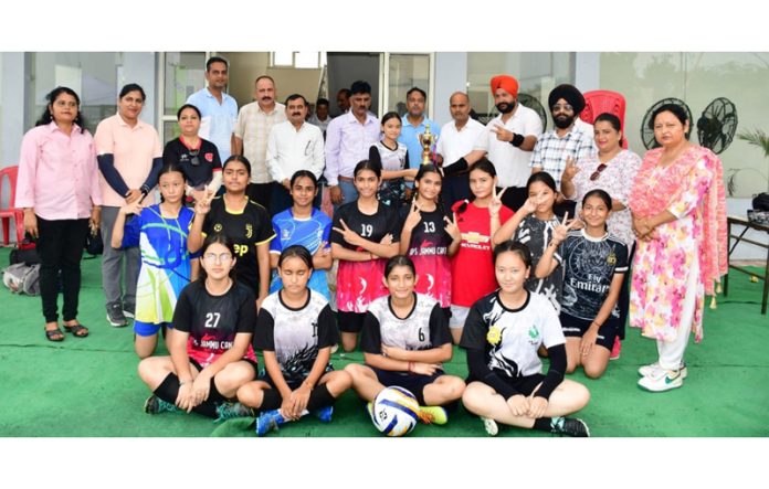 Dignitaries posing along with girl's football team.