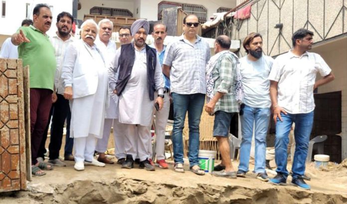 Senior NC leader Ajay Kumar Sadhotra along with party workers at a flood hit area of Jammu.